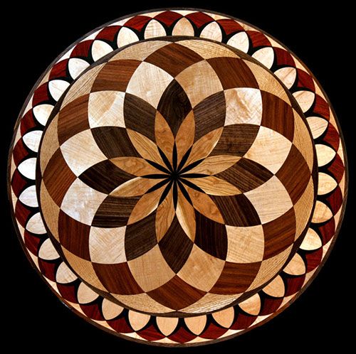 a circular wooden table top with an intricate design