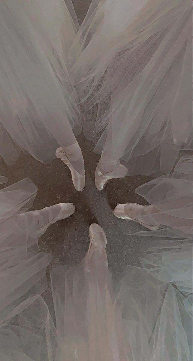 an abstract photograph of white tulle on a black and white background with one person's feet in the middle