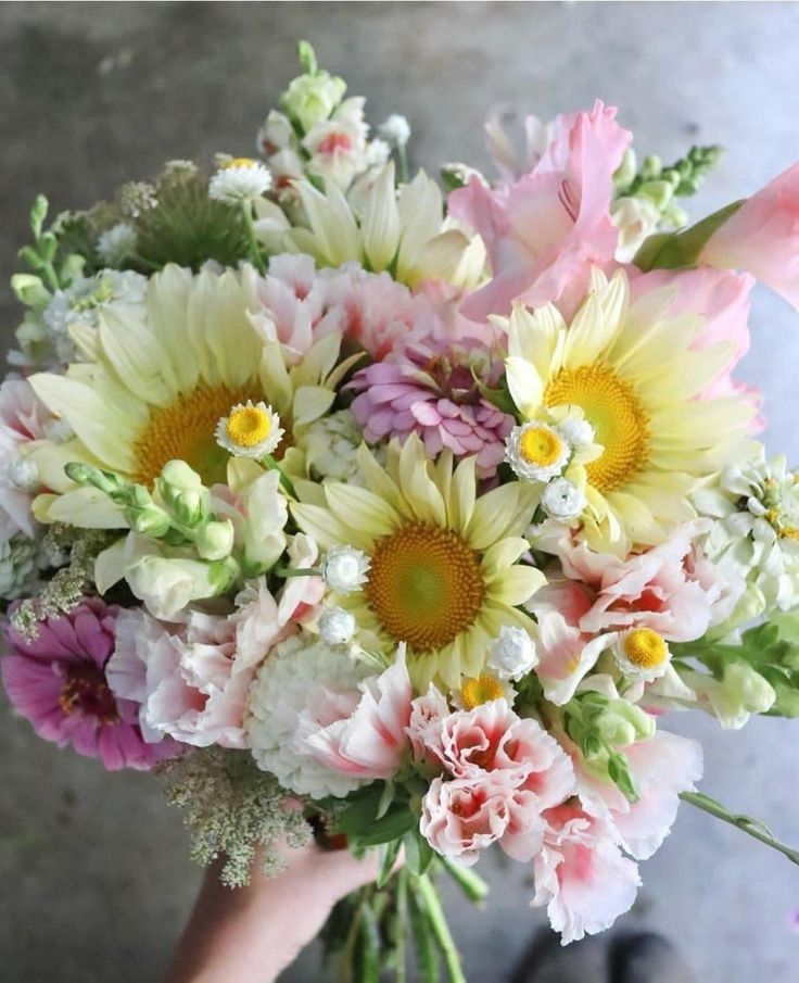 a person holding a bouquet of flowers in their hand