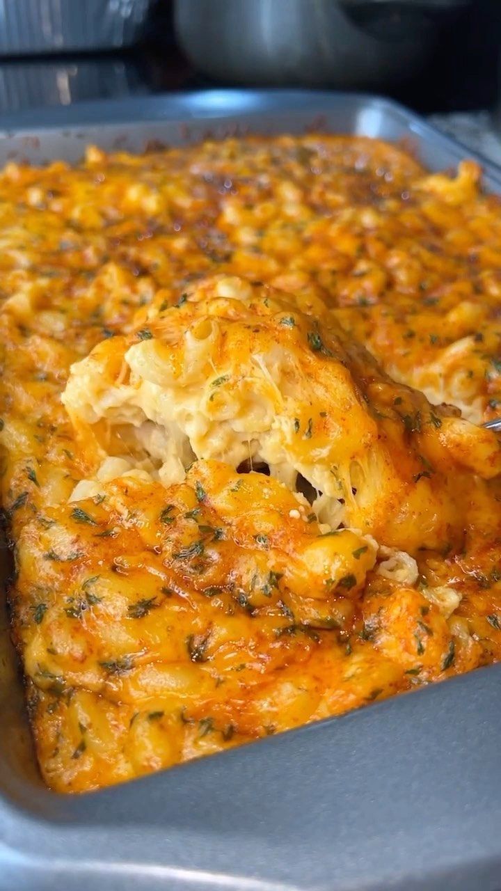 a casserole dish with cheese and herbs on top, in a baking pan