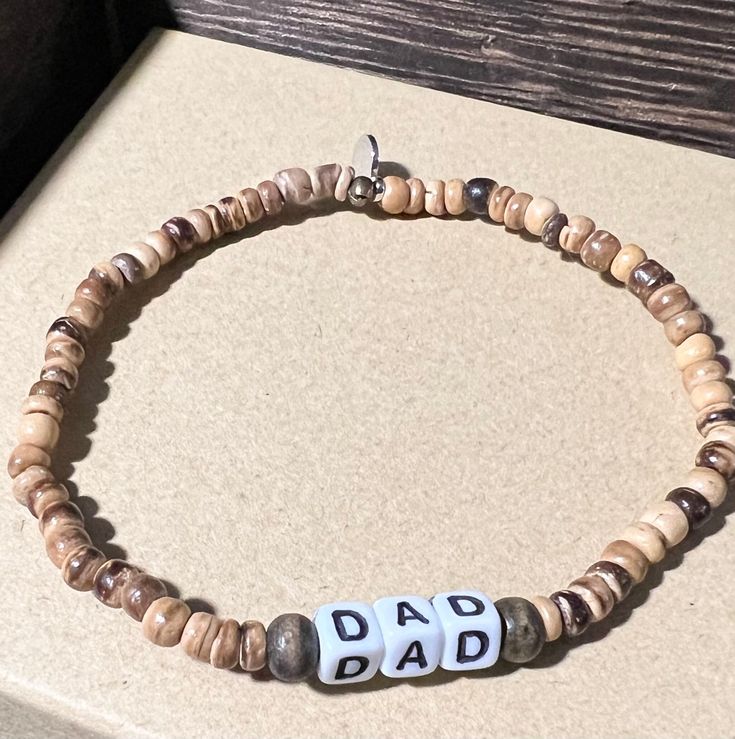 a beaded bracelet with the word dad written on it