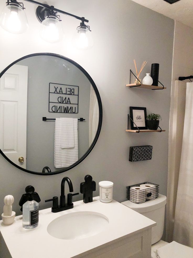 a bathroom with a round mirror above the sink