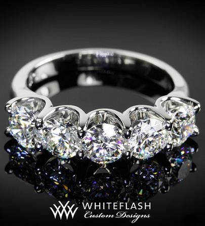 a diamond ring with five stones in it on a black surface, and the words whiteflash written below