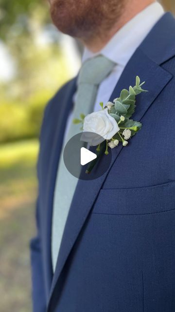 a man wearing a blue suit and flower boutonniere