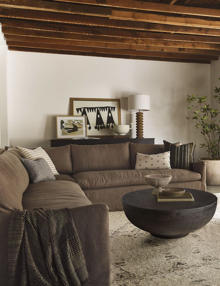 a living room with couches, tables and pictures hanging on the wall above them