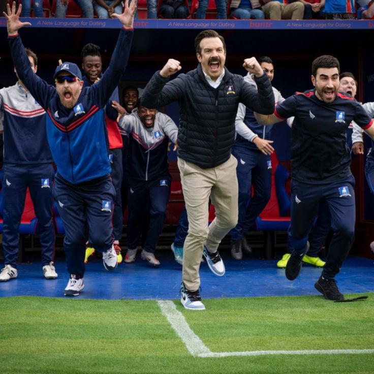 a group of men standing on top of a soccer field