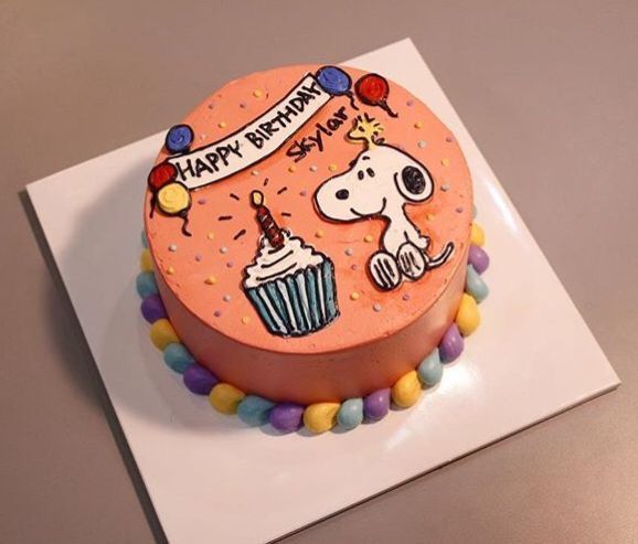 a birthday cake decorated with a dog and cupcakes