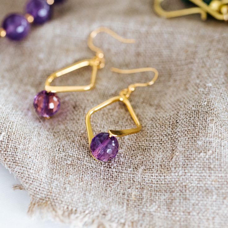 Faceted Amethyst Dangle Earrings - T. Randall Jewelry Gold Crystal Earrings With Faceted Beads, Diamond-shaped Earrings With Ear Wire For Gifts, Gold Faceted Crystal Earrings For Gift, Gold Faceted Brass Jewelry, Nickel-free Diamond-shaped Jewelry For Gifts, Faceted Gold Brass Jewelry, Nickel-free Diamond-shaped Jewelry Gift, Gift Diamond-shaped Earrings With Ear Wire, Yellow Gold Jewelry With Faceted Beads For Gift