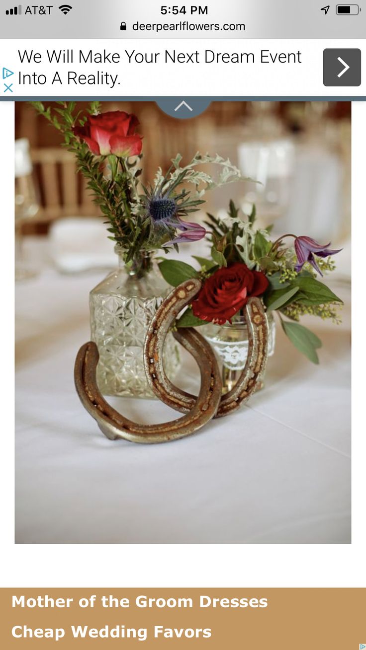 a vase with flowers in it sitting on a table next to some wine glasses and napkins