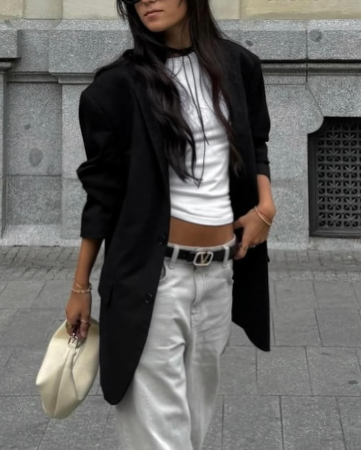 Fashion stylist Bianca Barese wearing a chic minimalist outfit with a black blazer, white crop top, and loose grey pants in Buenos Aires. Stradivarius Boots, Minimalist Street Style, Zara Tank Top, Minimal Street Style, Boots Vintage, Trendy Outfit, Simple White, Grey Pants, Effortless Chic