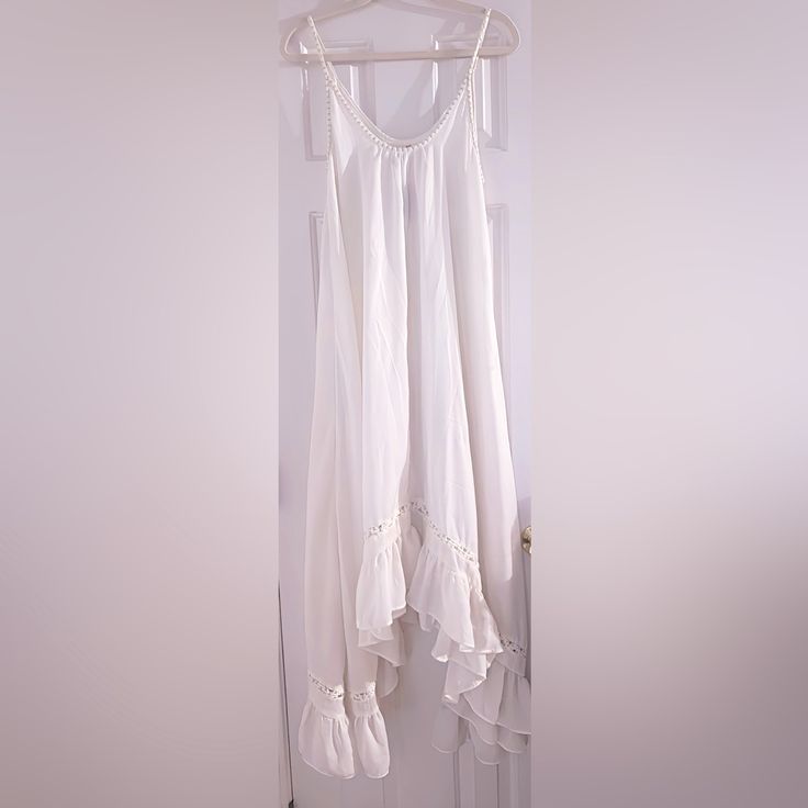 Long And Flowy With Ruffled Hem At Bottom. Nwt Ivory White Sleeveless Lace Trim Dress For Beach, White Sleeveless Ruffle Maxi Dress, Off White Sleeveless Sundress Maxi Dress, White Cotton Sleeveless Dress For Vacation, Off White Sleeveless Beach Dress, Cream Sleeveless Summer Maxi Dress, Cream Sleeveless Maxi Dress For Summer, Flowy White Sleeveless Dress For Vacation, Off White Sleeveless Dress For Vacation