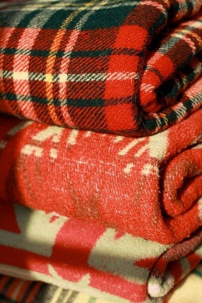 three red and green plaid blankets stacked on top of each other with the words, there is