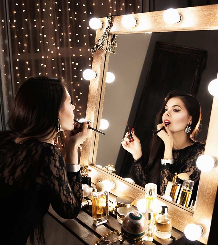 a woman is doing makeup in front of a mirror