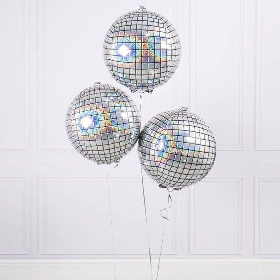 three silver disco ball balloons in front of a white wall