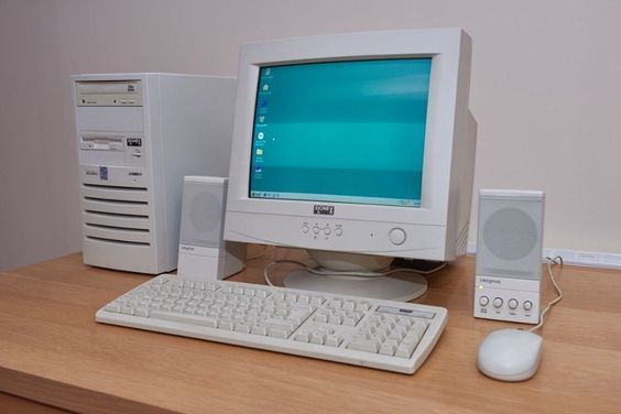 a desktop computer sitting on top of a wooden desk next to a keyboard and mouse