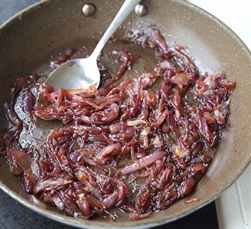 a frying pan filled with bacon on top of a stove