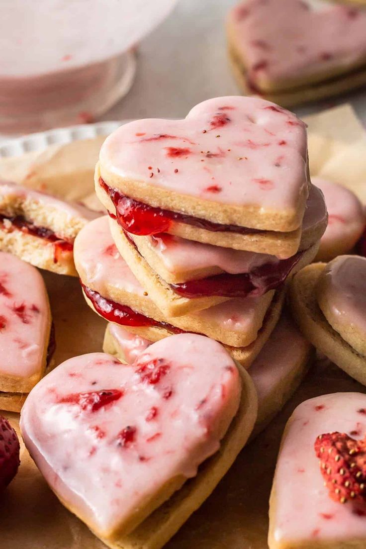 strawberry shortbreads with white frosting and strawberries on top are arranged in the shape of hearts