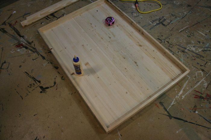 an unfinished wooden table with two bottles on it