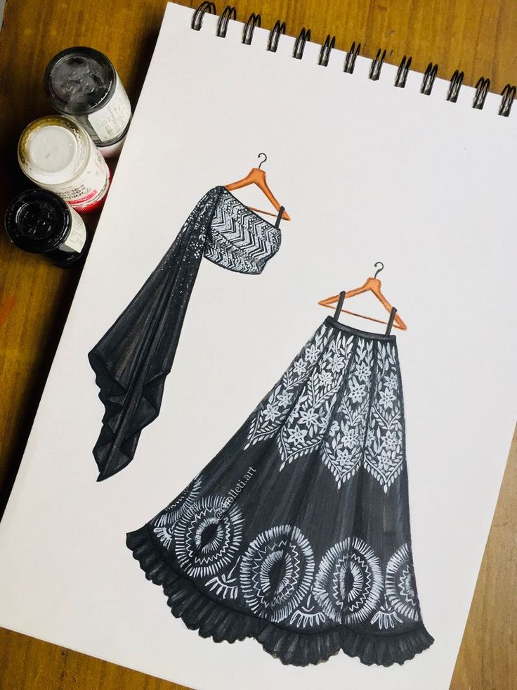 a drawing of two dresses on a table