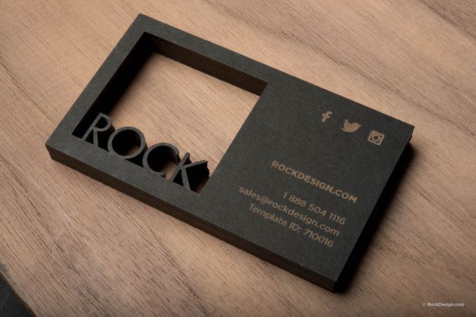 a black business card with the word rock cut out of it's side on a wooden table