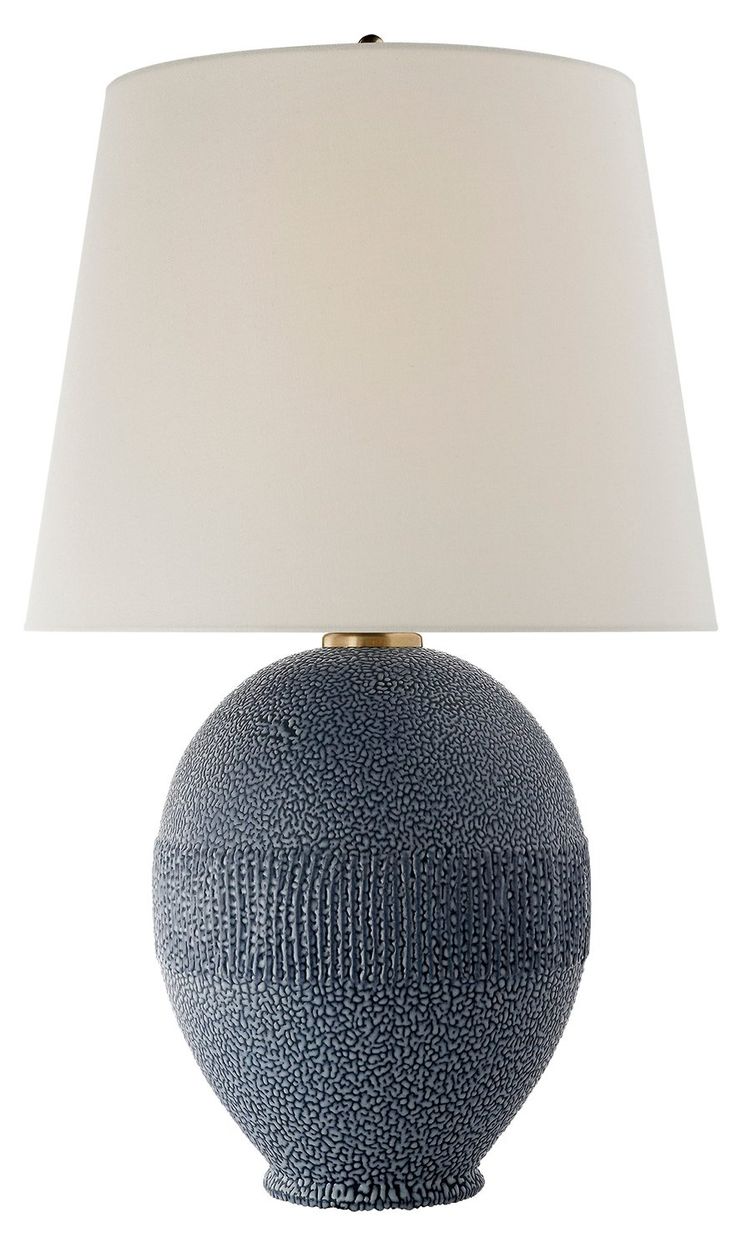 a blue ceramic table lamp with a white shade