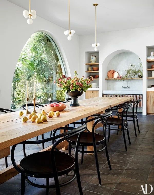 a long table with chairs and fruit on it