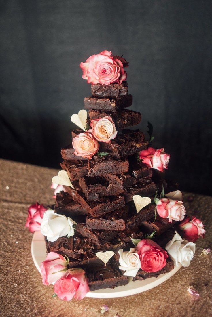 a chocolate cake with flowers on the top is sitting on a plate and it has been cut into pieces