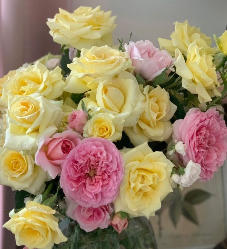 a vase filled with yellow and pink flowers