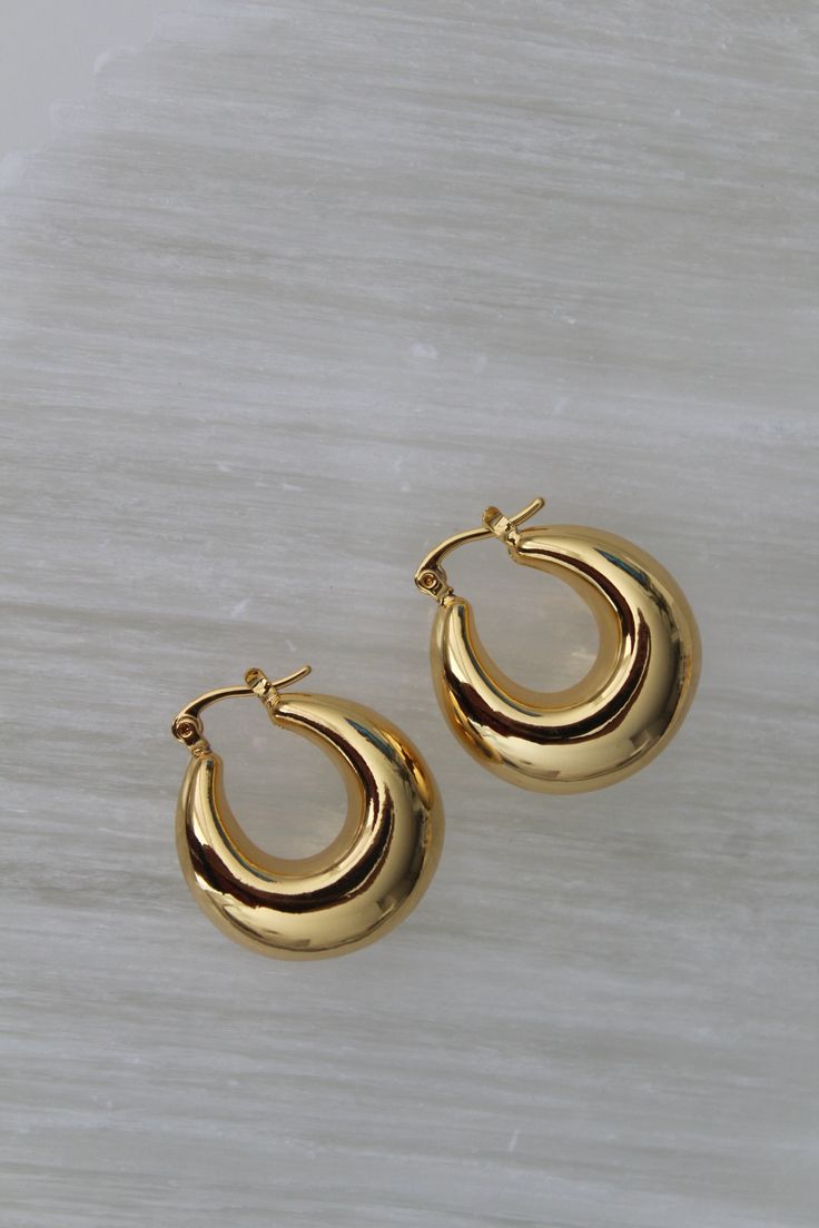 18k Gold Plated 12mmx25mm Brass Make a statement with our Chunky Gold U-Hoops—the perfect blend of boldness and elegance. These U-shaped earrings are crafted from high-quality, gold-plated material, offering a luxe, polished finish that complements any outfit. Designed for those who love a touch of vintage flair with modern appeal, these earrings are both versatile and timeless. Ideal for elevating your everyday style or adding a glamorous touch to your evening look, these Chunky Gold U-Hoops ar Elegant Gold-tone Earrings As Gift, Classic Chunky Gold Jewelry, Elegant Gold-tone Earrings For Gift, Chic Gold Earrings, Chic Gold Earrings With Shiny Finish, Classic Gold Chunky Jewelry, Luxury Gold Huggie Earrings With Shiny Finish, Elegant Gold Earrings For Work, Elegant Gold Earrings For Workwear