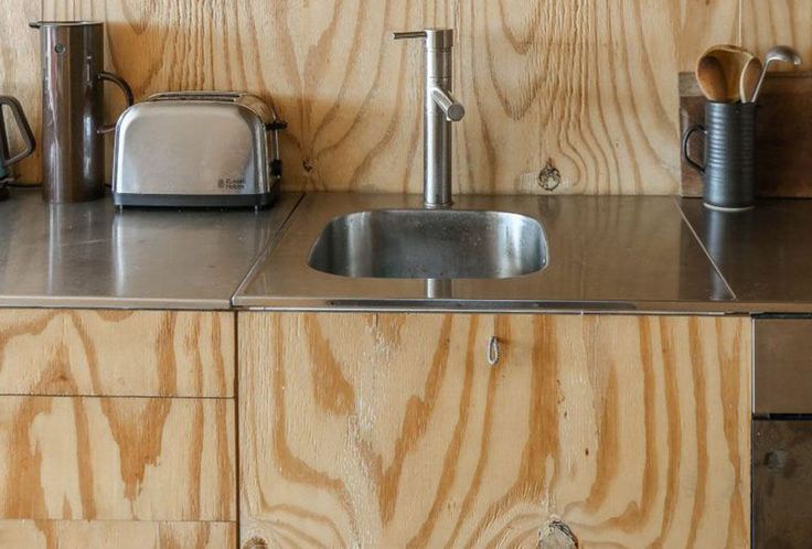 a kitchen counter with a sink, toaster and kettles on top of it