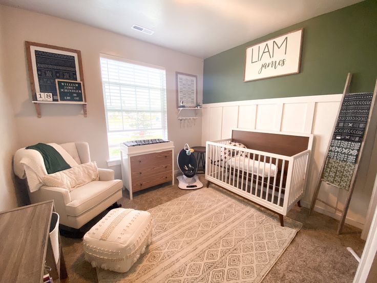 a baby's room with green walls and white furniture