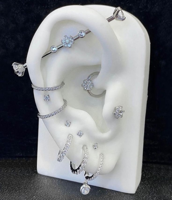 an earring and ring display in a white case with diamonds on the inside of it