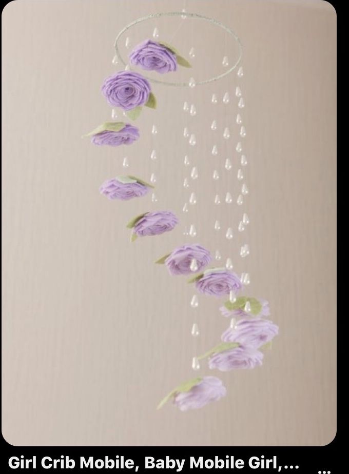 purple flowers are hanging from the ceiling with beads and water droplets on them, along with pearls