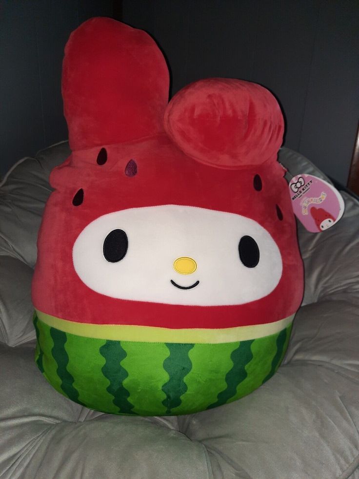 there is a large stuffed animal in the shape of a watermelon with ears