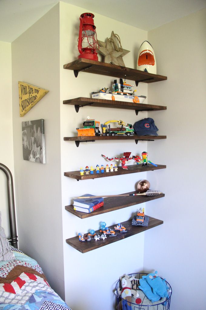 a bedroom with shelves and toys on the wall