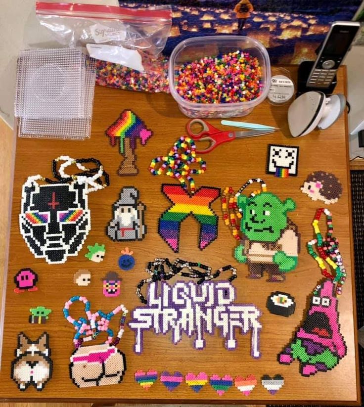 a wooden table topped with lots of crafting supplies and beads on top of it