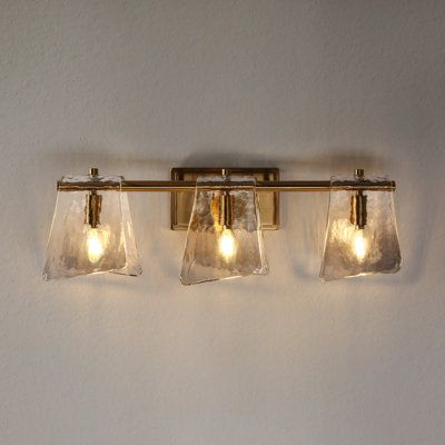 three lights that are on the side of a wall