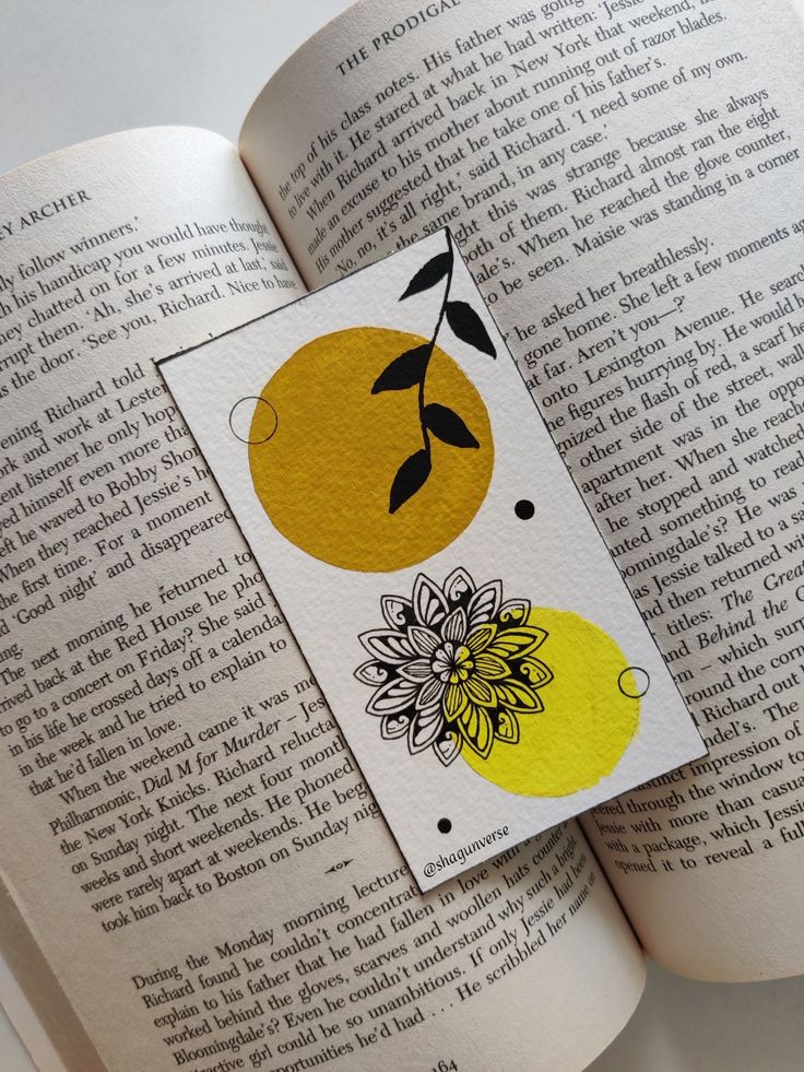 an open book with yellow and black flowers on the pages, next to a white background