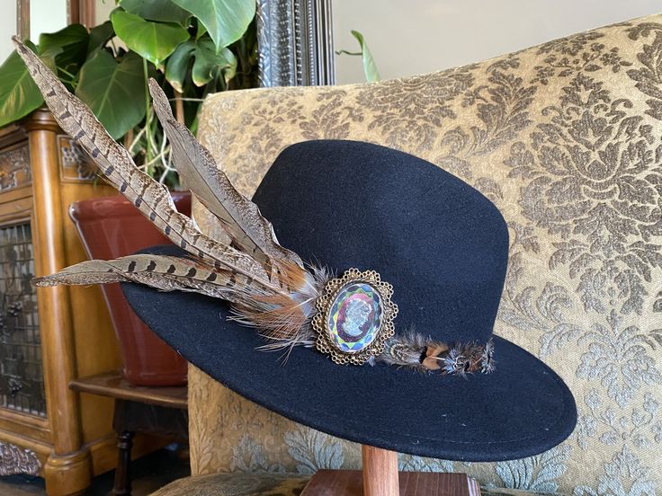 All of my creations are hand picked, hand crafted and one of a kind. My hats are inspired by the Victorian Era and art forms like Art Nouveau and Art Deco. All of my pieces bring a sense of elegance by intertwining the old and new. Each hat is hand picked and then dressed up with feathers, stone beads, a stone cabochon and a vintage cameo. No single hat is the same and all hats are designed to be their own. All the names are based off of my close friends or a song from one of my favorite musicians.  This hat is called the "Shana" -Hat Style : "Women's" Panama 100% Wool - Cameo : Iridescent glass cameo on top of a gold brushed metal backing. Dates back to the 1970's. -Feather : Pheasant  -Cabochon : Moonstone -Stone Bead String: Amethyst, tigers eye, jasper, agate and labradorite. -Size : 5 Bohemian Fedora With Short Brim As Gift, Handmade Short Brim Fedora As Gift, Handmade Fedora With Short Brim As Gift, Artistic Handmade Short Brim Hat, Unique Handmade Short Brim Hat, Handmade Artisan Costume Hats For Festivals, Handmade Bohemian Costume Hat With Curved Brim, Artistic Curved Brim Hat As A Gift, Artistic Hat With Curved Brim As Gift