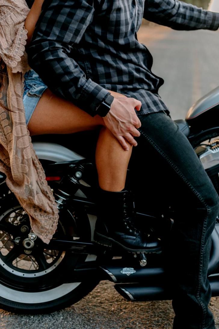 a woman sitting on the back of a motorcycle next to a man in plaid shirt