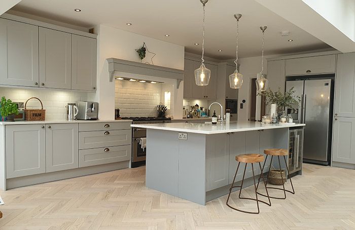 a kitchen with an island and two stools next to it on a hard wood floor