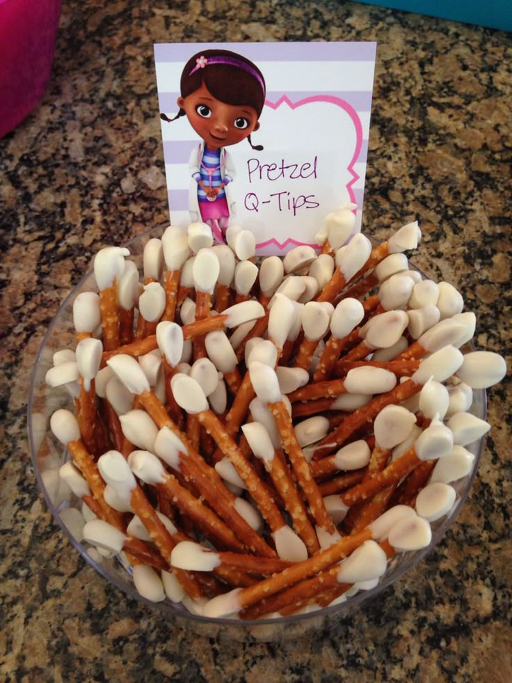 a bowl filled with pretzels and marshmallows on top of a table