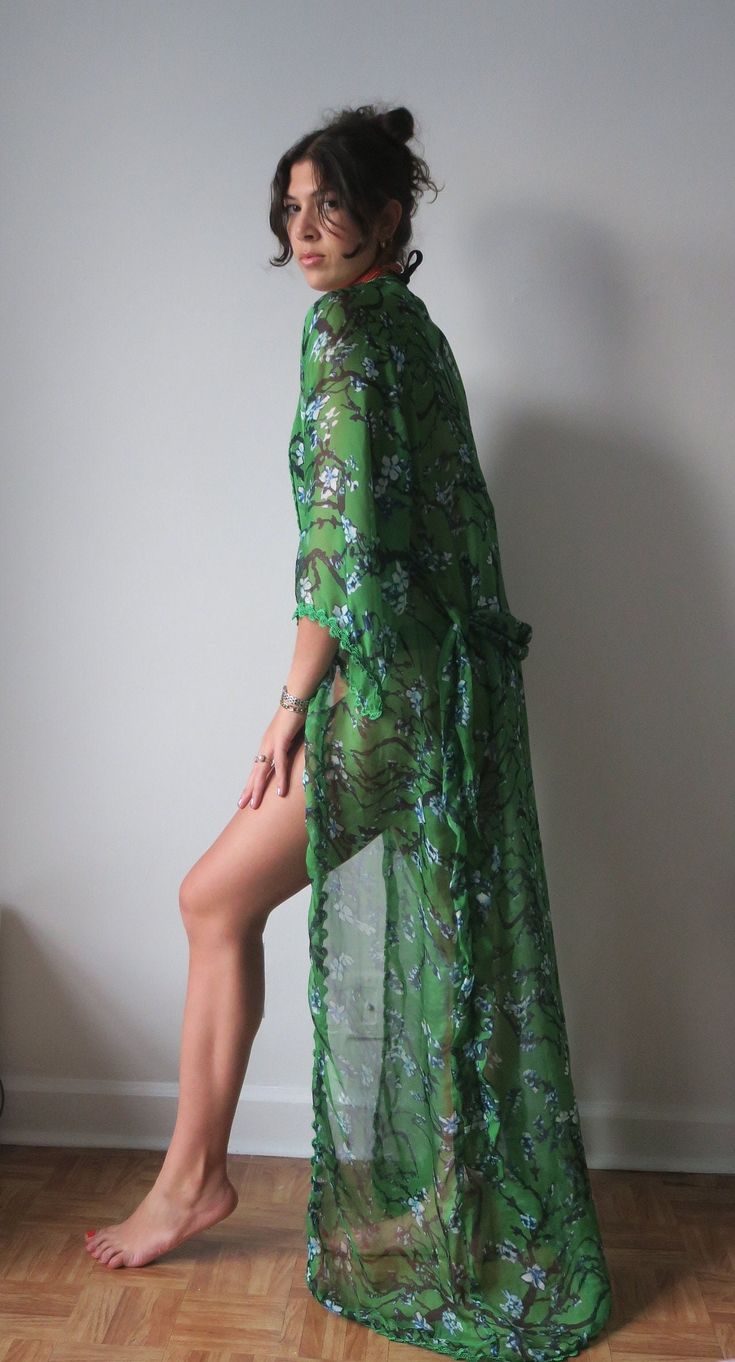 Flowy floral kimono - perfect coverup for your tropical vacation or layered over an outfit for a pop of color and style. Belted closure with gorgeous green trimming around all sides and sleeves. Model is 5'10" size 6/8. 100% silk organza Luxury Green Elegant Kimono, Green Long Floral Print Kimono, Long Green Floral Print Kimono, Long Green Kimono With Floral Print, Green Long Kimono With Floral Print, Spring Green Floral Print Kaftan, Green Wrap Kaftan For Beach, Green Wrap Kaftan For The Beach, Green Floral Print Summer Kimono