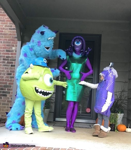 three people in costumes standing on the front steps of a house, one holding out his hand to another person who is dressed as monsters