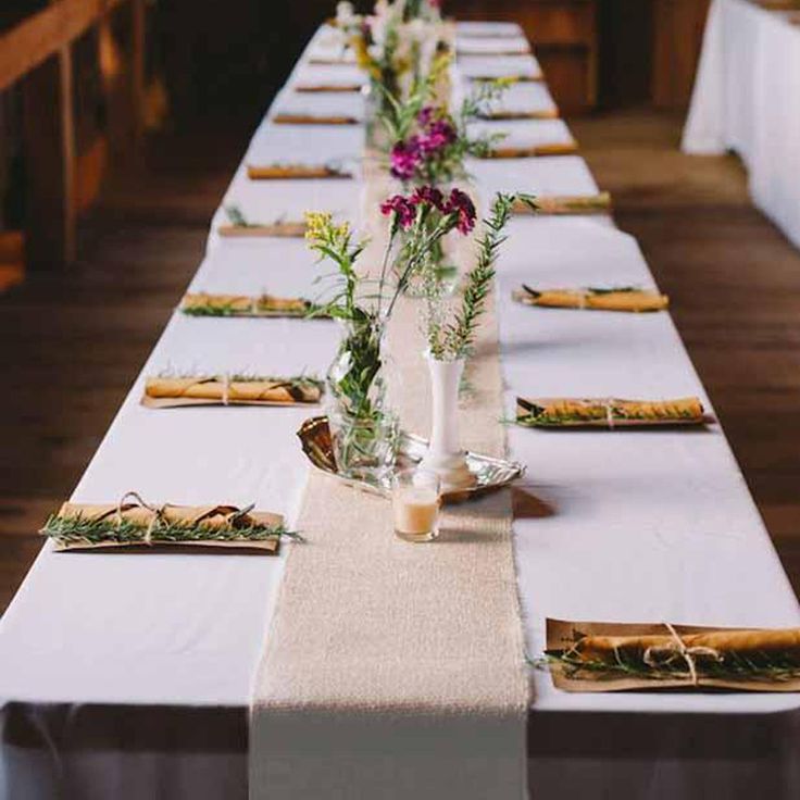 a long table is set up with flowers and place mats for the guests to sit down