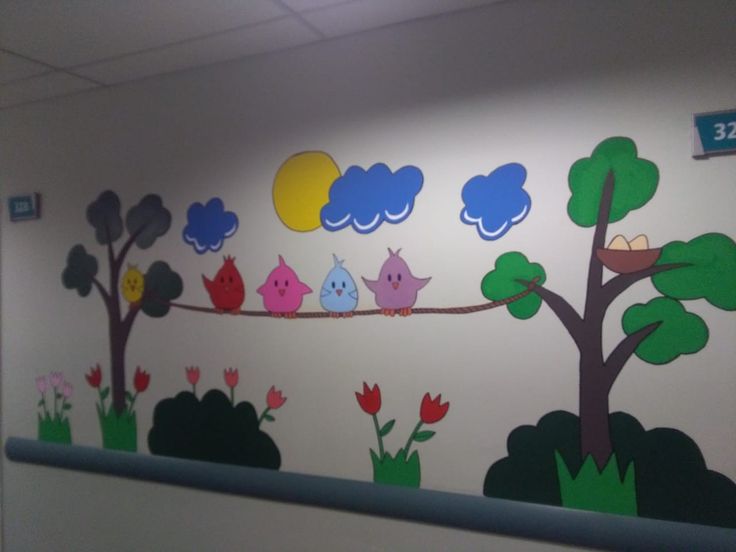 an office wall painted with trees, flowers and birds on the branch in front of it