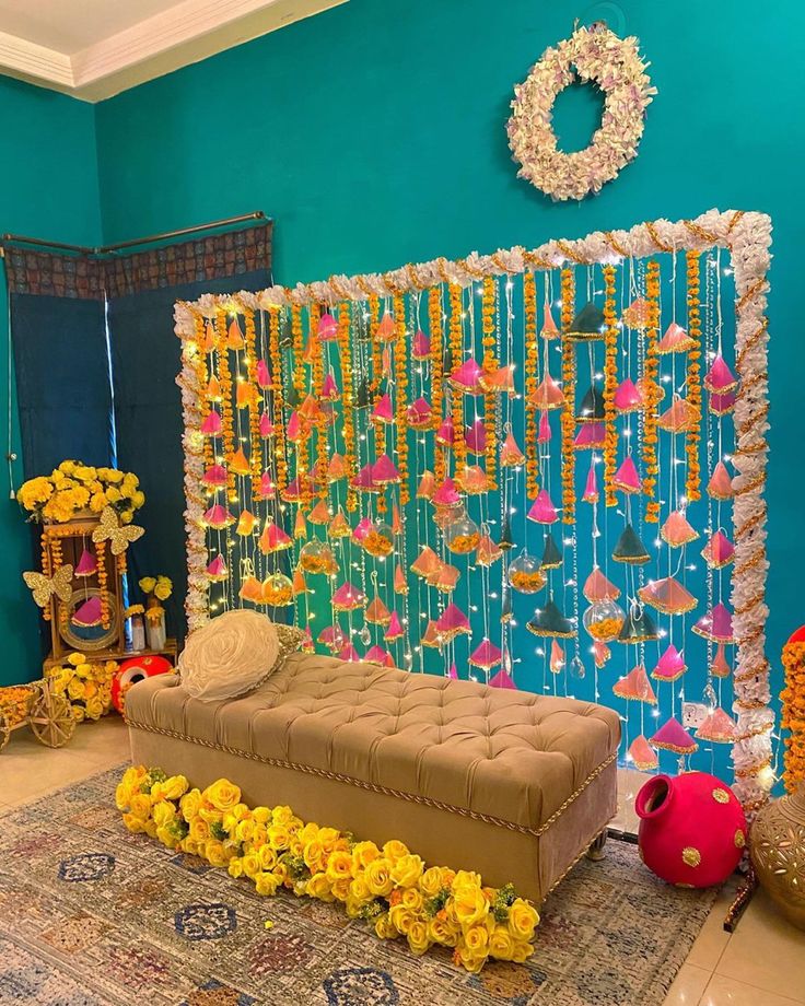 a room decorated with flowers and decorations on the wall, including a couch in front of a backdrop