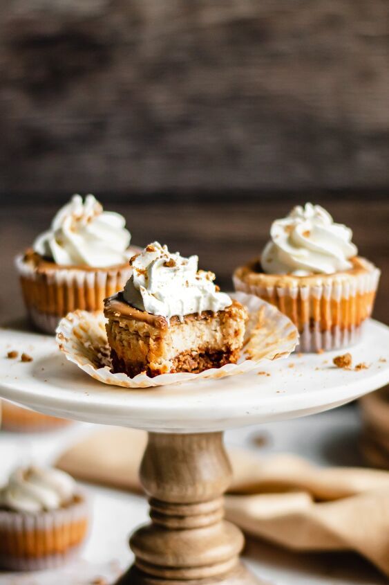 three cupcakes with white frosting on a cake plate