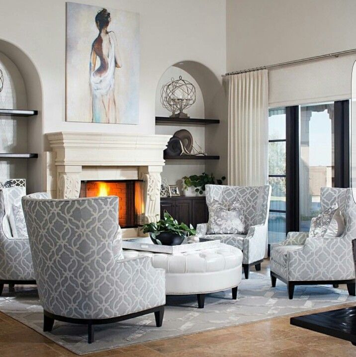 a living room filled with furniture and a fire place in the middle of the room