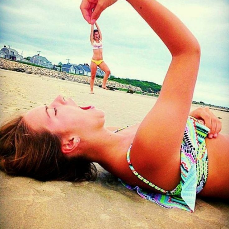 a woman laying on top of a sandy beach